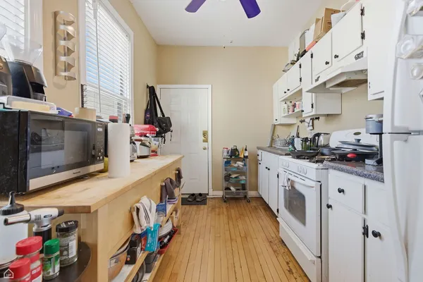 a kitchen with stainless steel appliances granite countertop a stove and a wooden floor