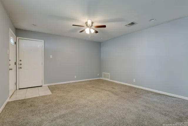 an empty room with closet and a chandelier fan