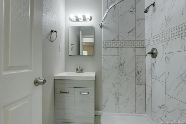 a bathroom with a shower and a sink