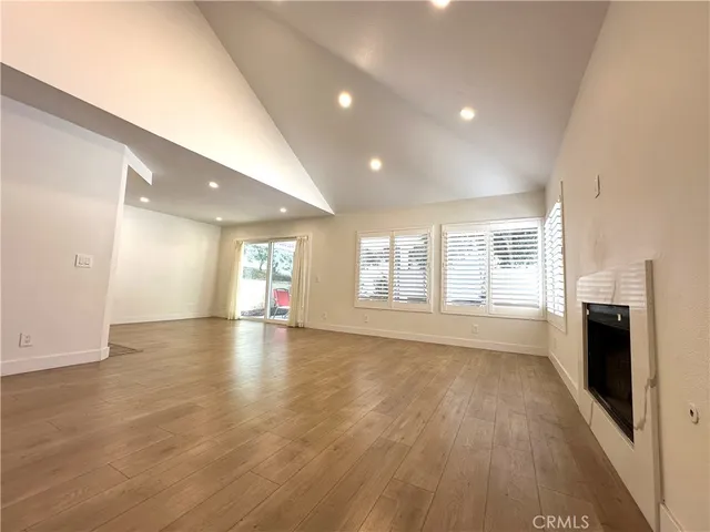 an empty room with wooden floor and fireplace