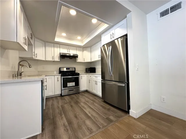 a kitchen with stainless steel appliances a refrigerator sink and microwave