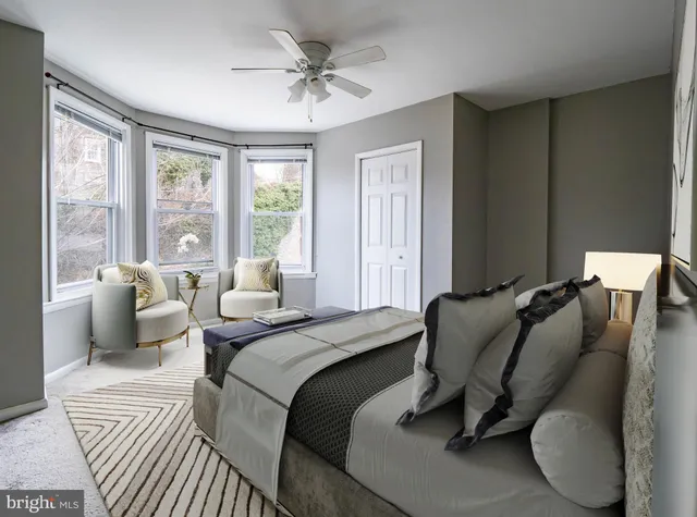 a bedroom with a bed and large windows