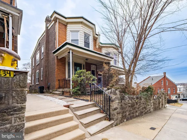 a front view of a house with a tree in front