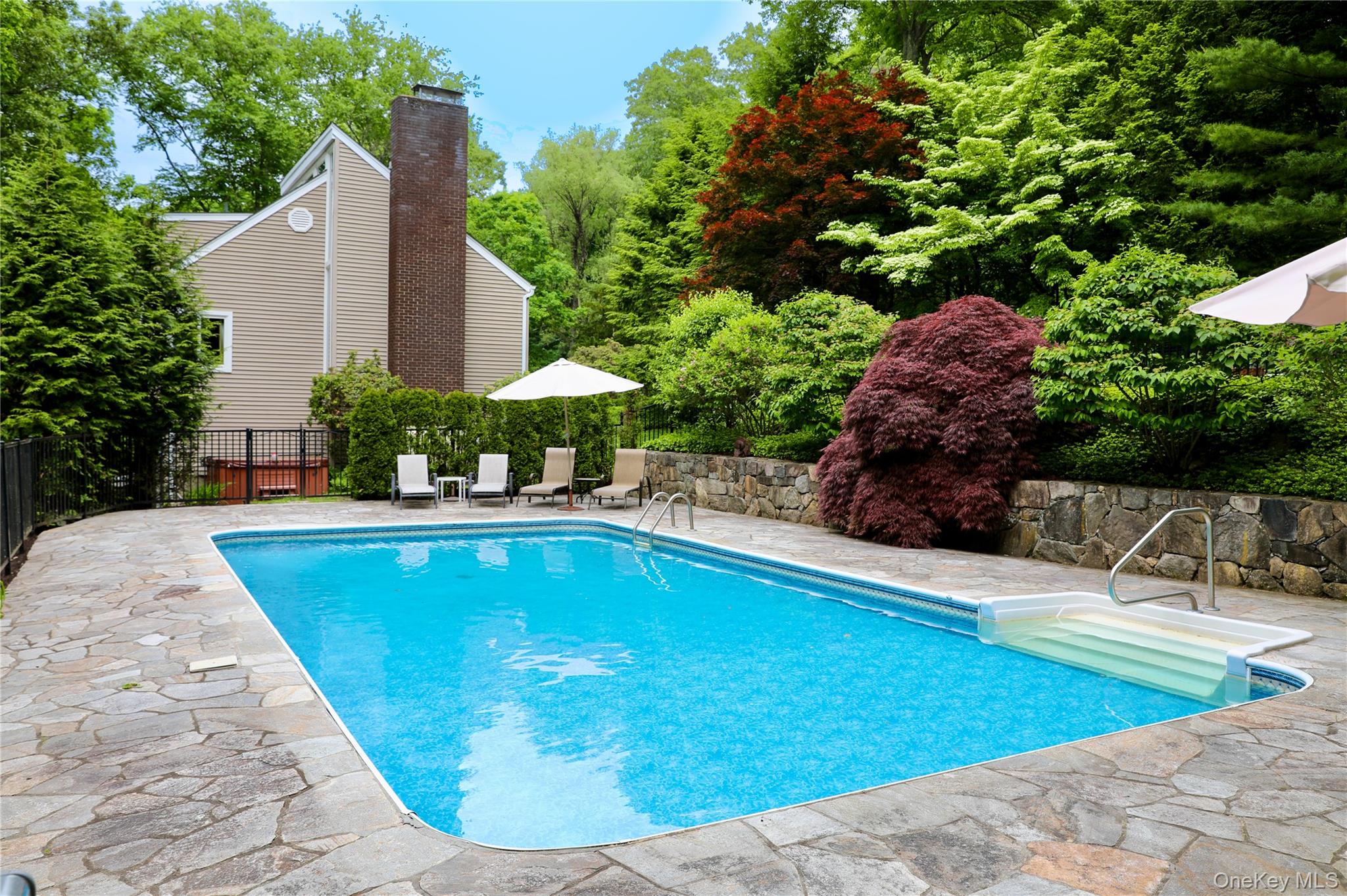 7 David Road Somers, NY 10589 - Photo 6 of 41 Inground pool with stone patio surrounded by mature landscaping