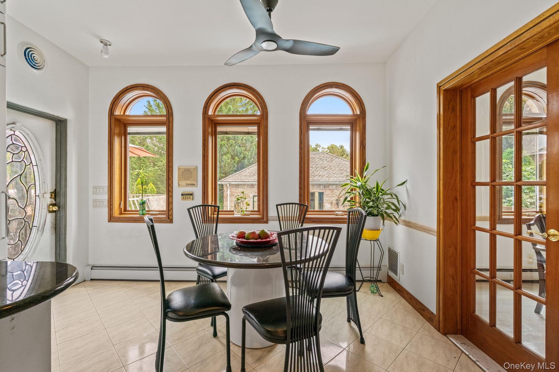 6 Summit Place Queens, NY 11357 - Photo 11 of 35 Dining room featuring light tile patterned floors, ceiling fan, and a baseboard heating unit