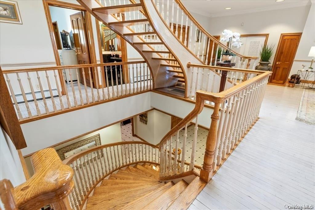 6 Summit Place Queens, NY 11357 - Photo 19 of 35 Stairs featuring washer / clothes dryer, crown molding, a baseboard heating unit, and hardwood / wood-style floors