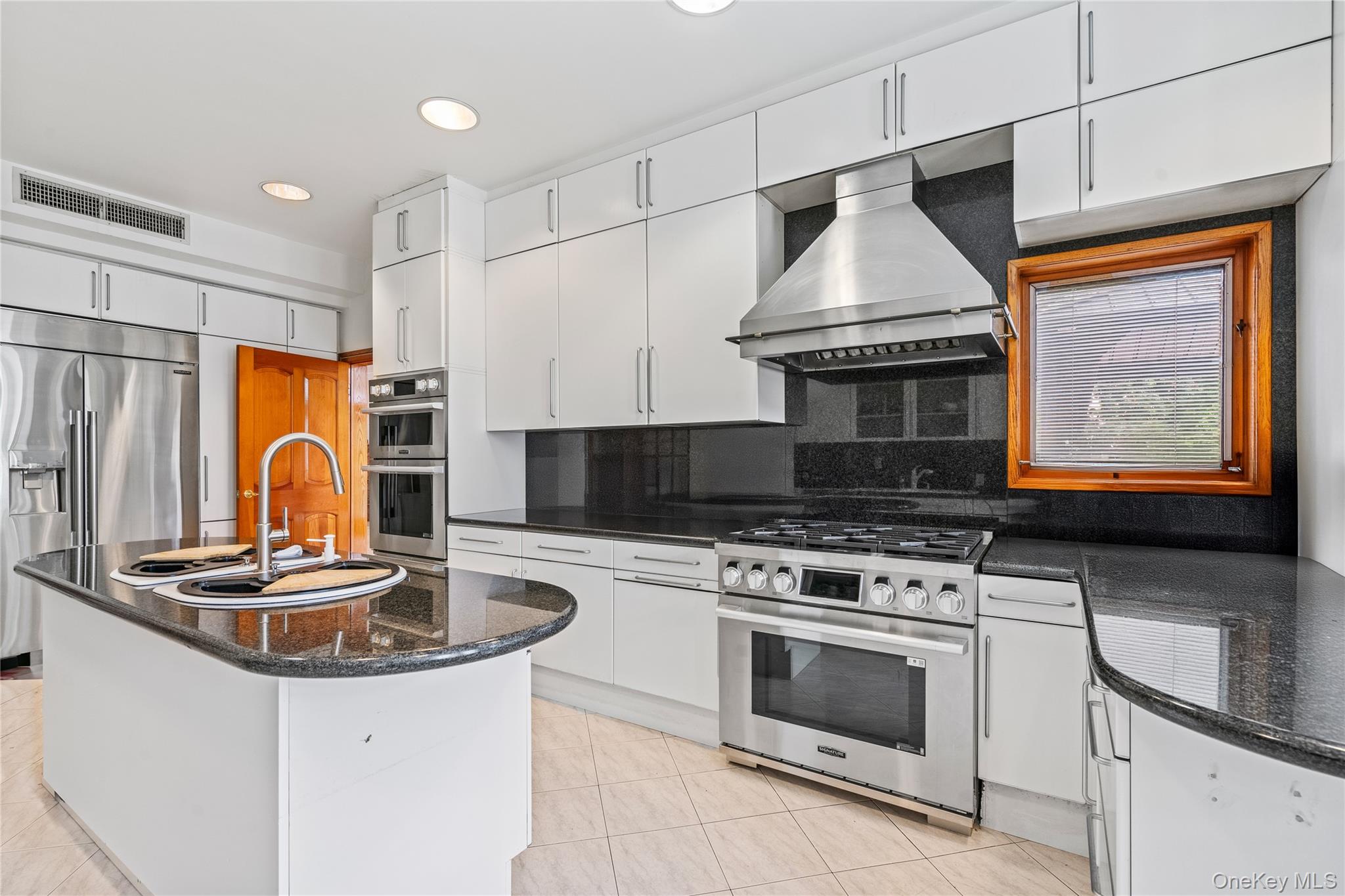 6 Summit Place Queens, NY 11357 - Photo 20 of 48 Kitchen featuring dark stone counters, white cabinetry, appliances with stainless steel finishes, recessed lighting, and island exhaust hood