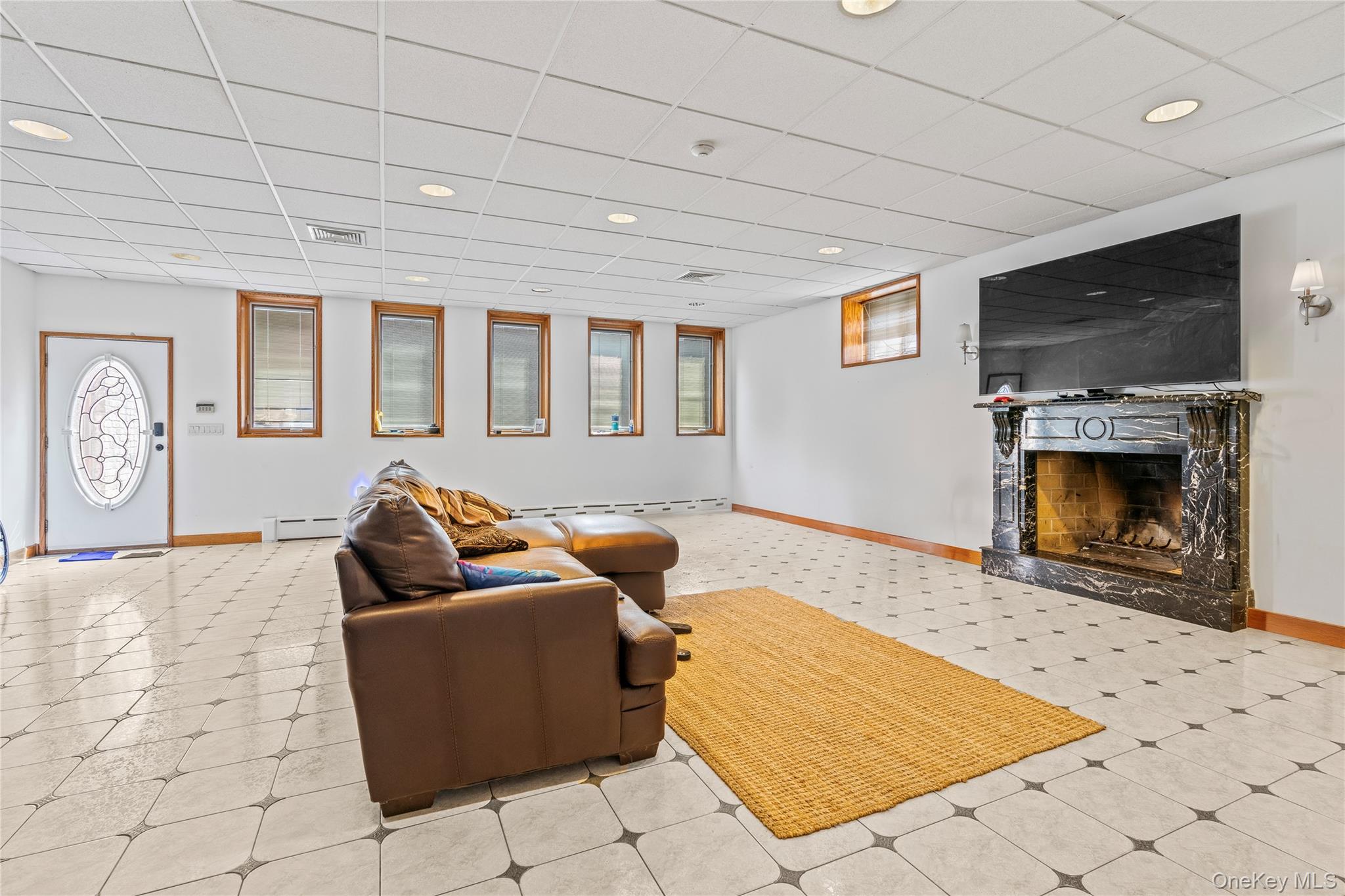6 Summit Place Queens, NY 11357 - Photo 22 of 35 Living area featuring healthy amount of natural light, a high end fireplace, a drop ceiling, recessed lighting, and a baseboard radiator