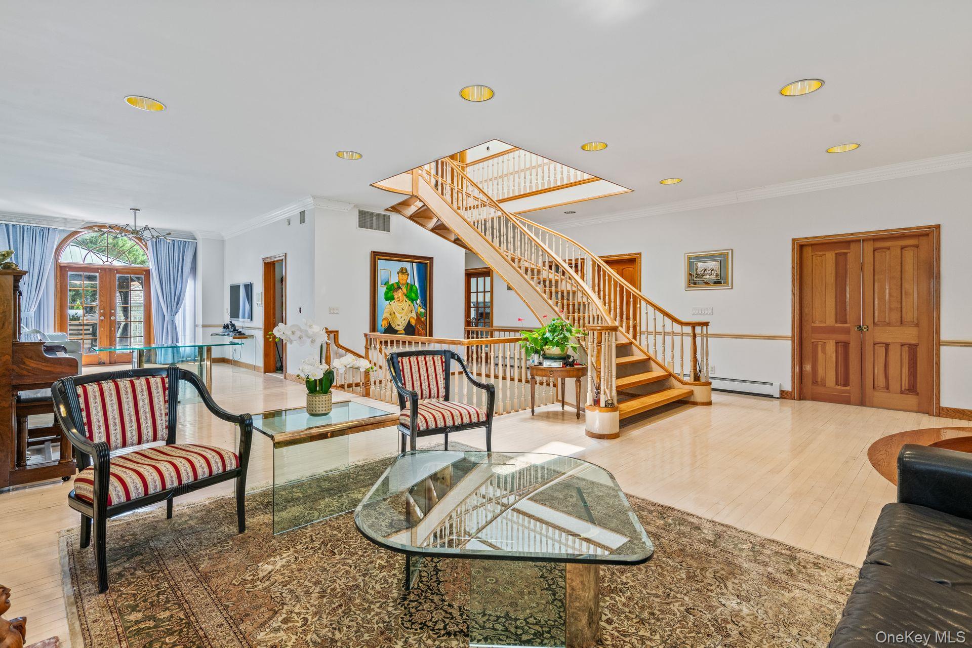 6 Summit Place Queens, NY 11357 - Photo 8 of 35 Living room featuring crown molding, light wood-type flooring, french doors, stairs, and recessed lighting