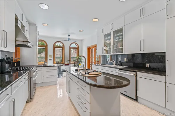 a kitchen with stainless steel appliances granite countertop a stove a sink a refrigerator and a dining table