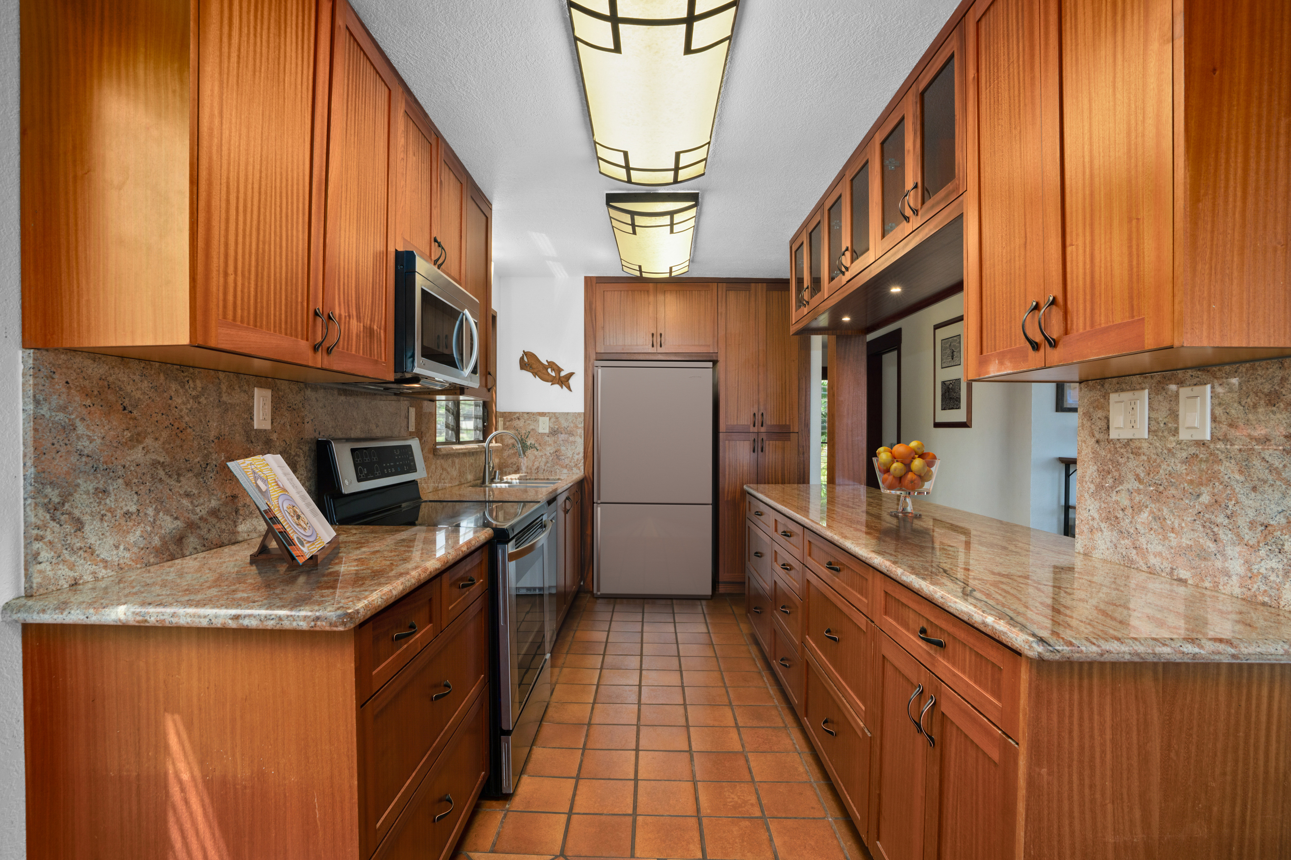 1870 Hoone Road, Unit 511 Koloa, HI 96756 - Photo 8 of 30 a kitchen with stainless steel appliances granite countertop a refrigerator a stove and a sink with wooden cabinets