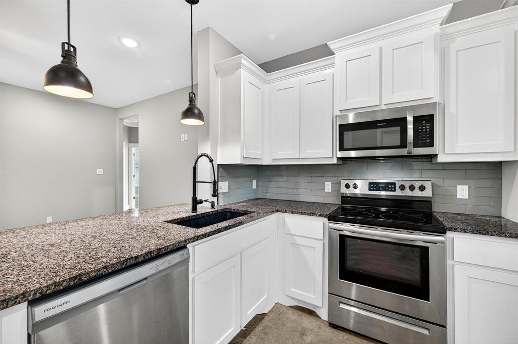 1501 South 7th Avenue Denison, TX 75021 - Photo 11 of 32 a kitchen with granite countertop a stove and a sink