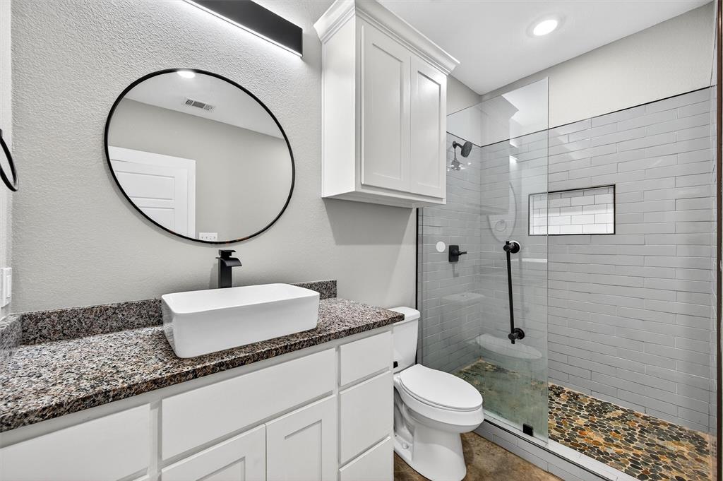 1501 South 7th Avenue Denison, TX 75021 - Photo 23 of 32 a bathroom with a granite countertop toilet sink and mirror