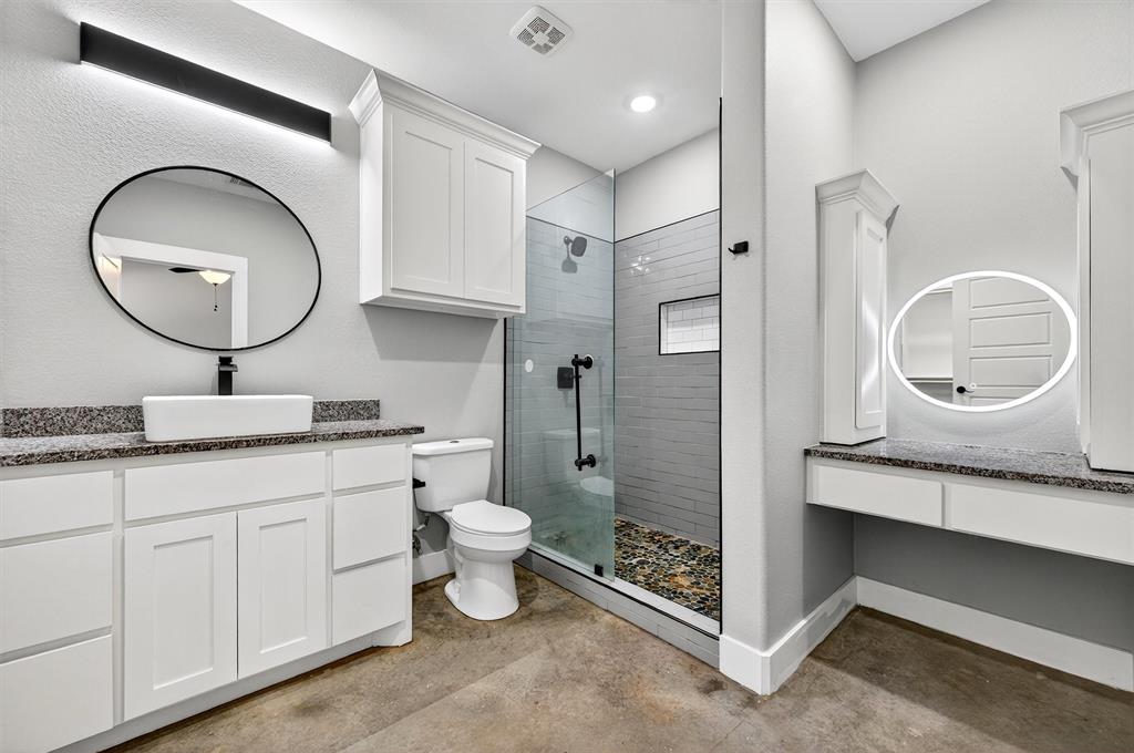 1501 South 7th Avenue Denison, TX 75021 - Photo 24 of 32 a bathroom with a toilet a double vanity sink and a mirror