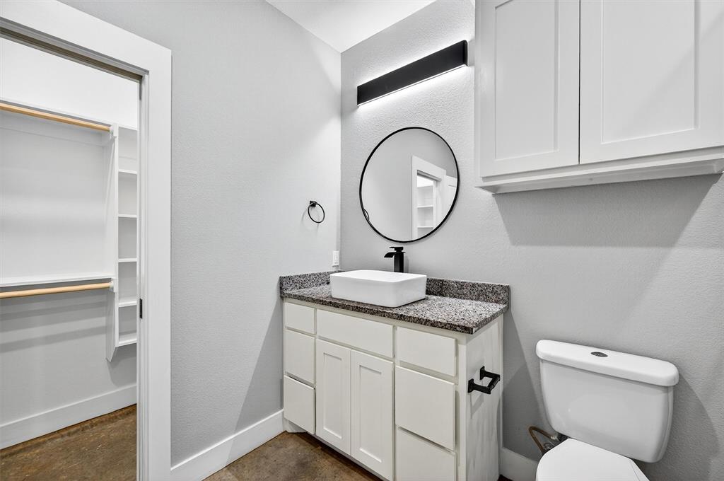 1501 South 7th Avenue Denison, TX 75021 - Photo 26 of 32 a bathroom with a granite countertop toilet sink and mirror