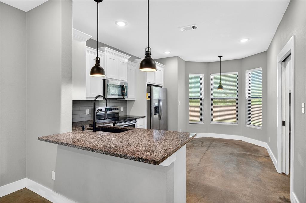 1501 South 7th Avenue Denison, TX 75021 - Photo 9 of 32 a kitchen with kitchen island stainless steel appliances granite countertop a sink a stove and a wooden floors