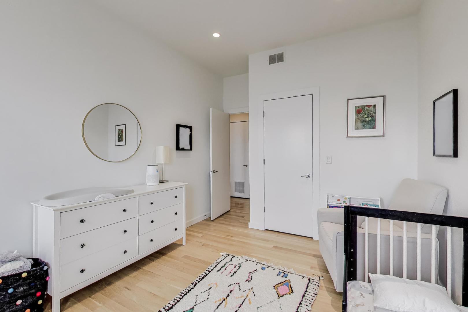4410 North Troy Street, Unit 301 Chicago, IL 60625 - Photo 17 of 23 a bedroom with a bed a mirror and a dresser