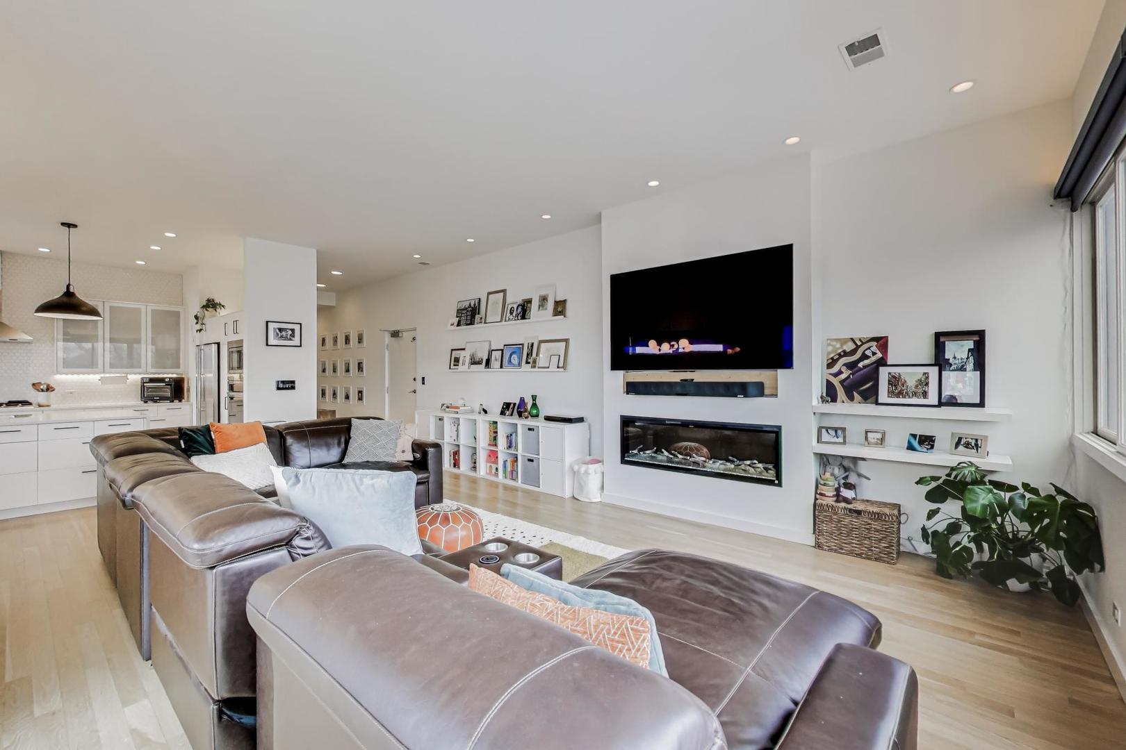 4410 North Troy Street, Unit 301 Chicago, IL 60625 - Photo 3 of 23 a living room with furniture a flat screen tv and a fireplace