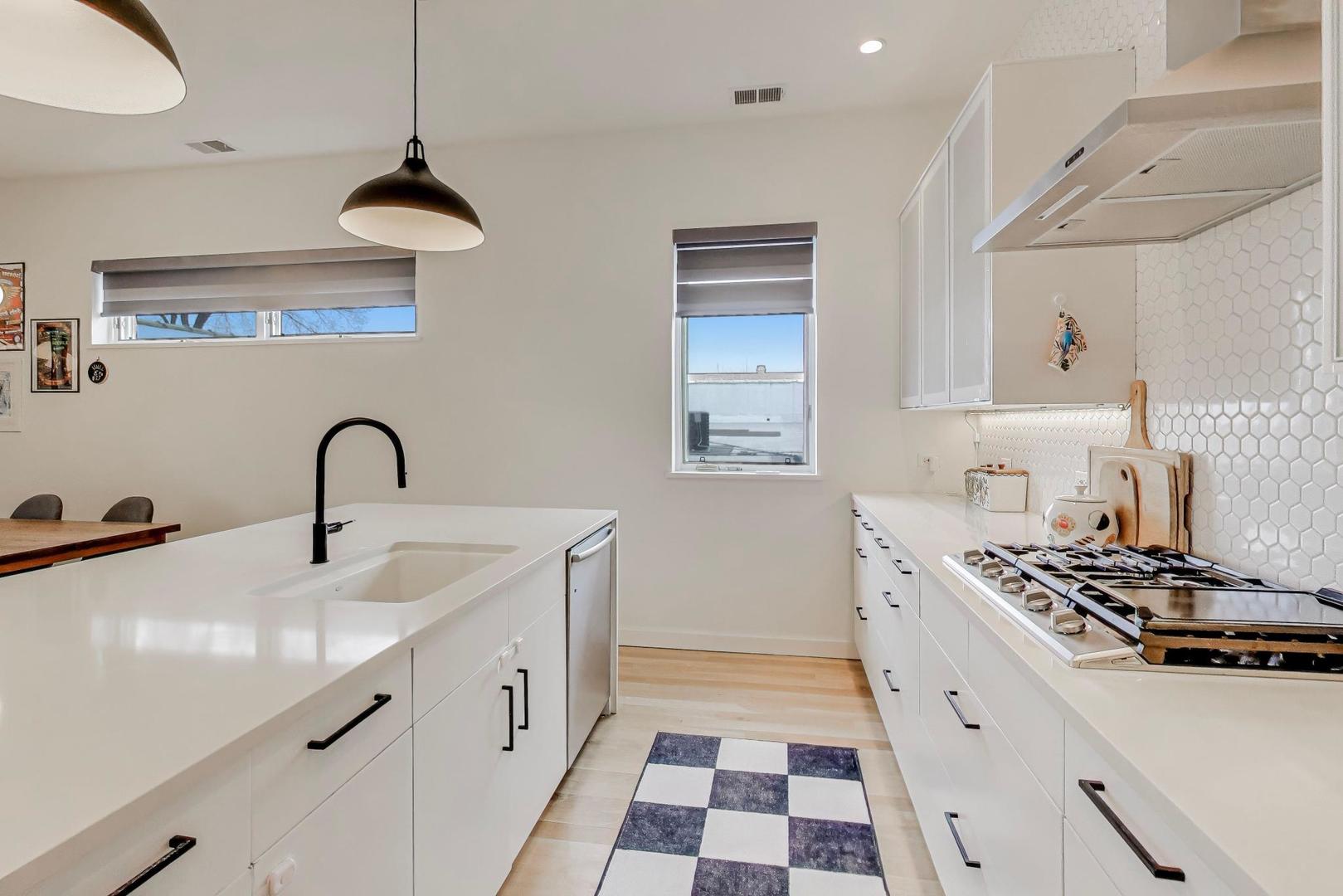 4410 North Troy Street, Unit 301 Chicago, IL 60625 - Photo 9 of 23 a kitchen with stainless steel appliances a sink a stove and a wooden floors