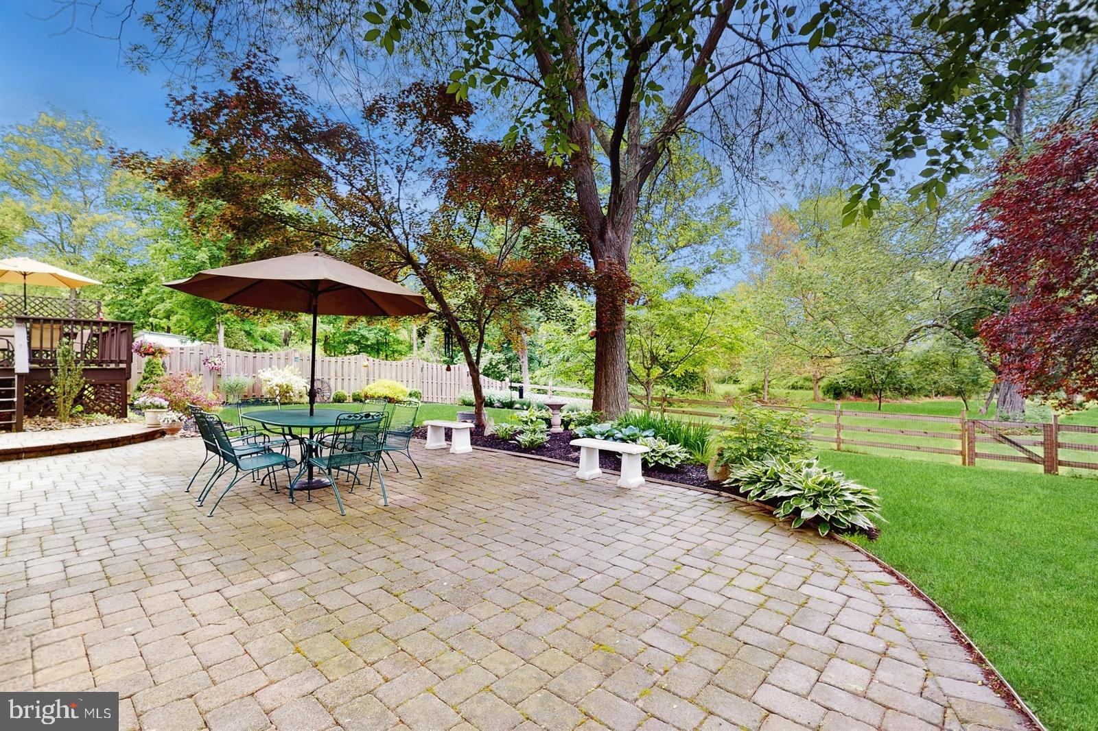 6 John Ringo Road Ringoes, NJ 08551 - Photo 20 of 27 a view of a patio with table and chairs under an umbrella with large trees