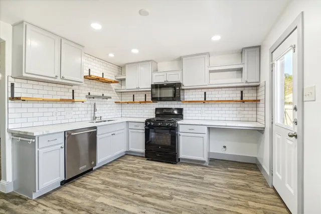 a kitchen with stainless steel appliances granite countertop a stove and white cabinets