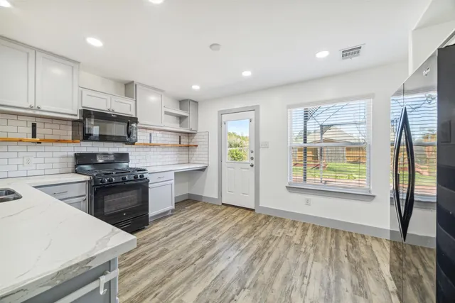 a kitchen with stainless steel appliances granite countertop a stove a sink and a refrigerator