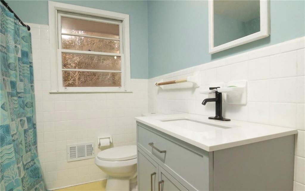 98 Almon Church Road Covington, GA 30014 - Photo 18 of 22 a bathroom with a sink a toilet and vanity