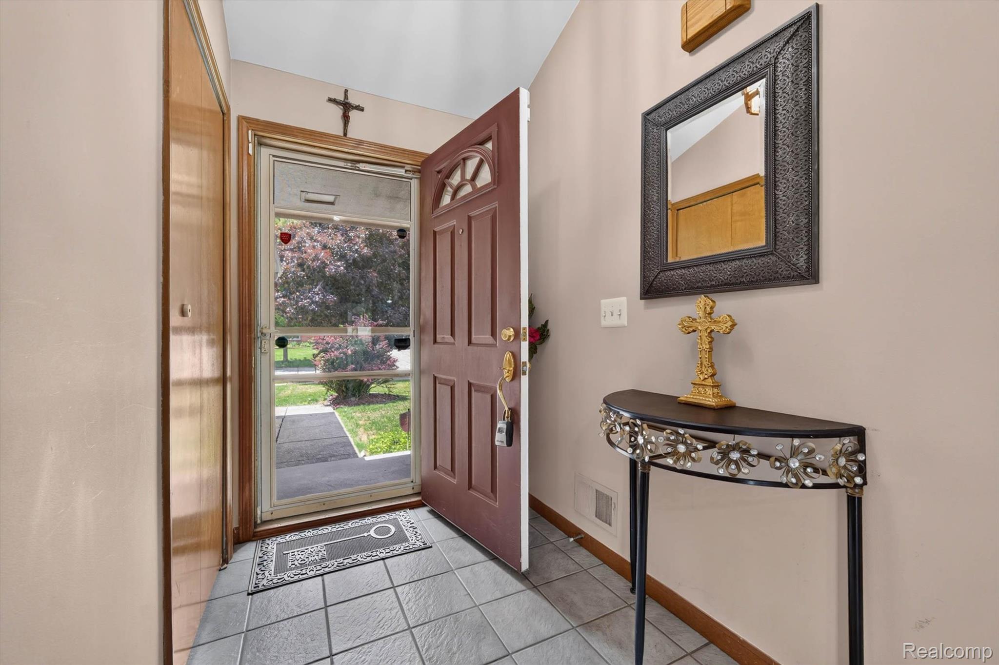 46362 Springhill Drive Utica, MI 48317 - Photo 5 of 59 Entryway featuring gray square tile flooring, a solid brown entry door with transom window, and a screen door