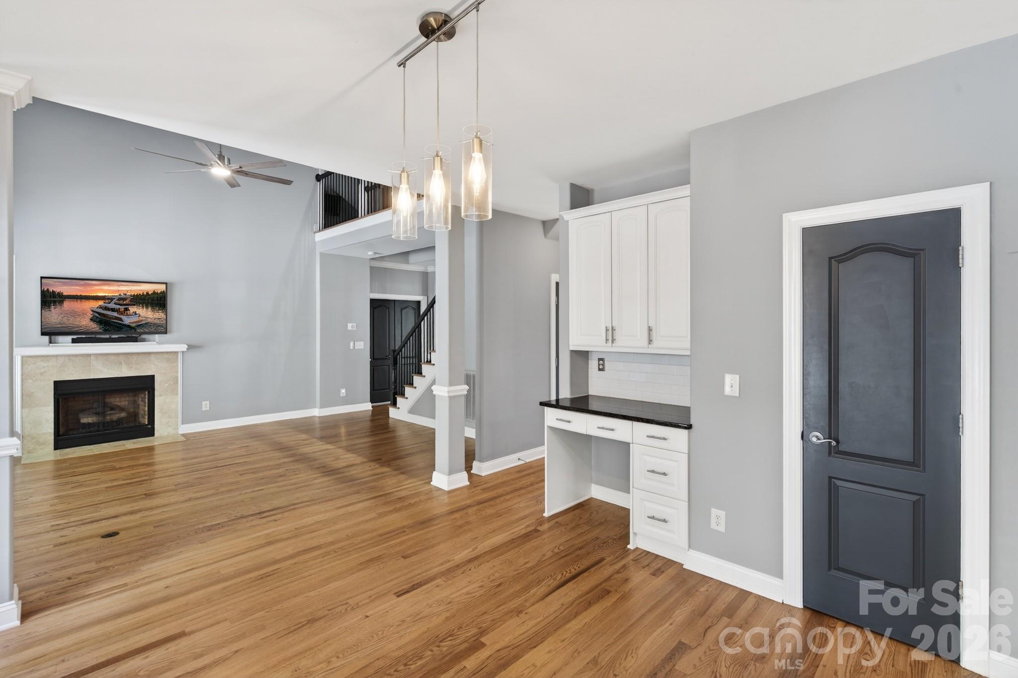 9101 Pitcairn Drive Tega Cay, SC 29708 - Photo 12 of 48 a view of a kitchen with wooden floor and a fireplace