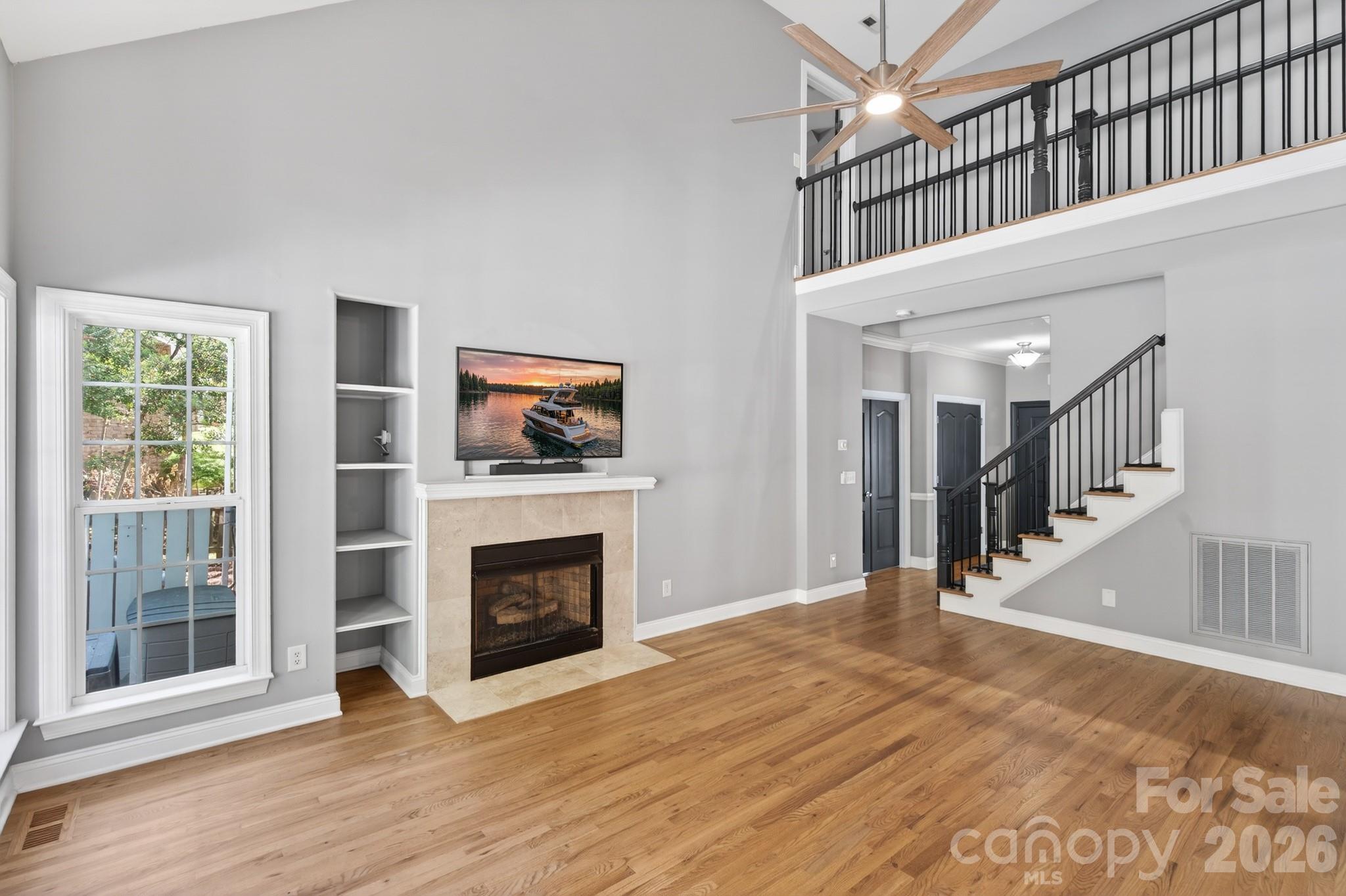9101 Pitcairn Drive Tega Cay, SC 29708 - Photo 13 of 48 a view of an empty room with wooden floor fireplace and a window