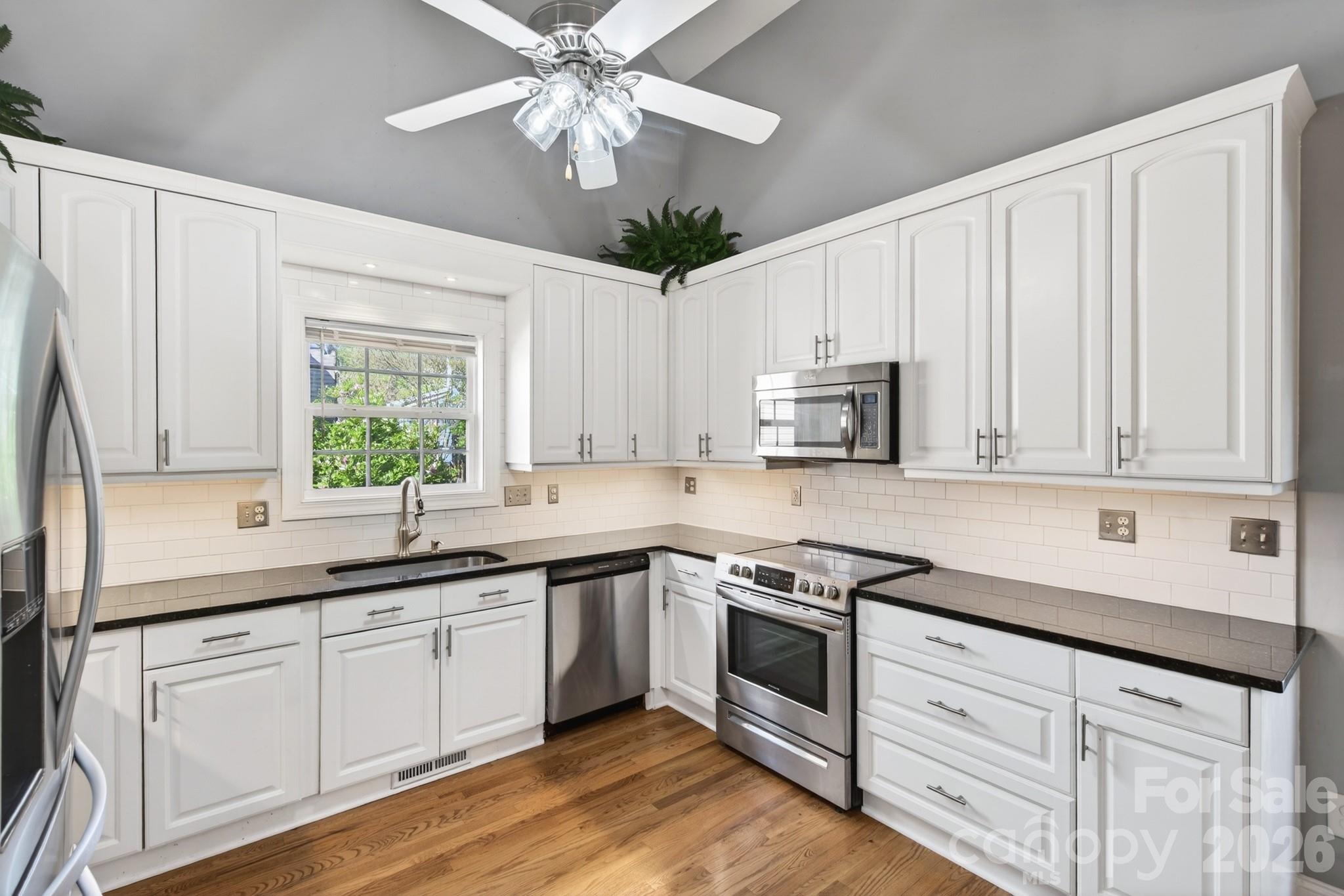 9101 Pitcairn Drive Tega Cay, SC 29708 - Photo 20 of 48 a kitchen with granite countertop white cabinets white stainless steel appliances and sink