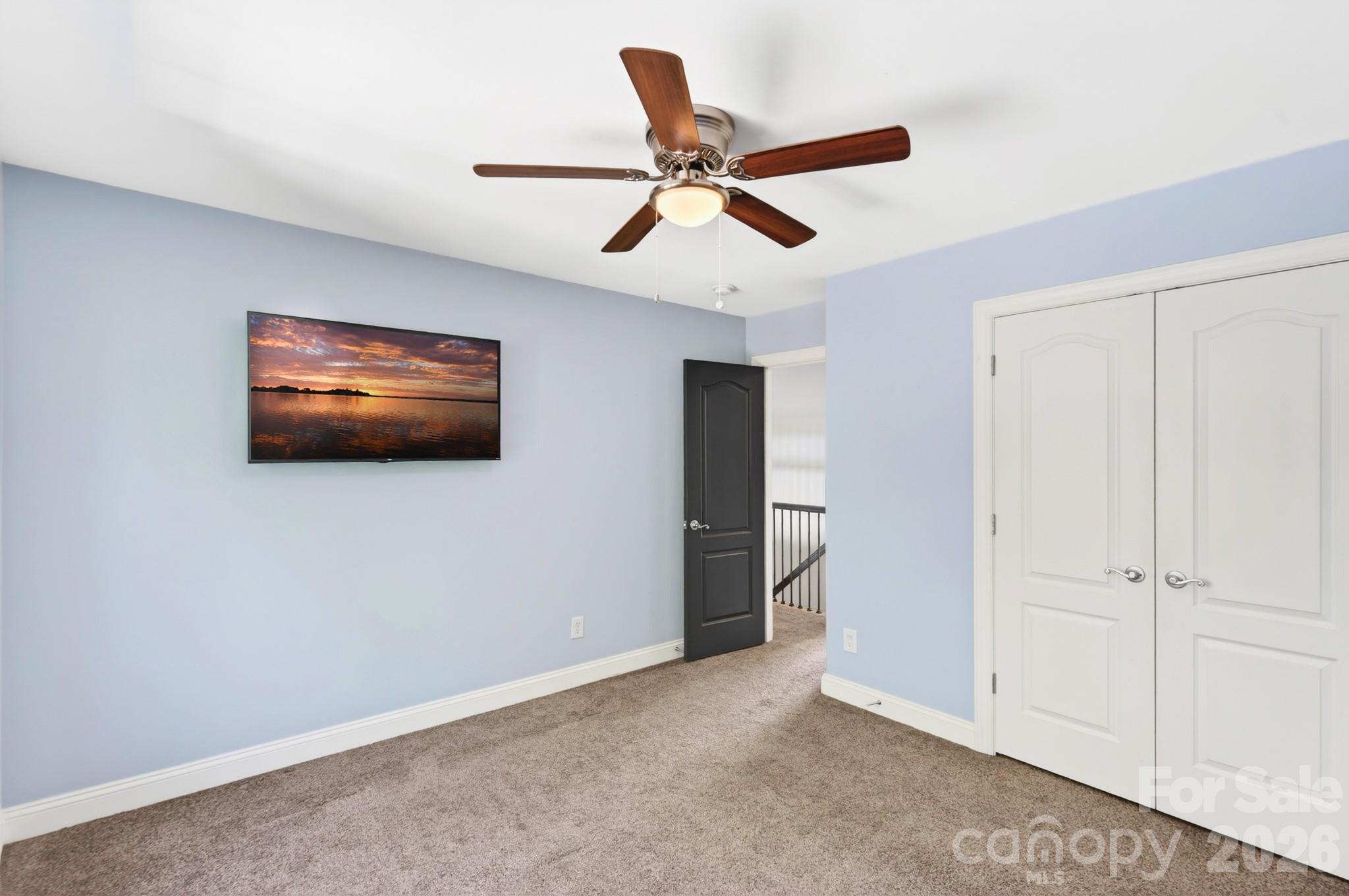 9101 Pitcairn Drive Tega Cay, SC 29708 - Photo 28 of 48 a living room with flat screen tv and a ceiling fan