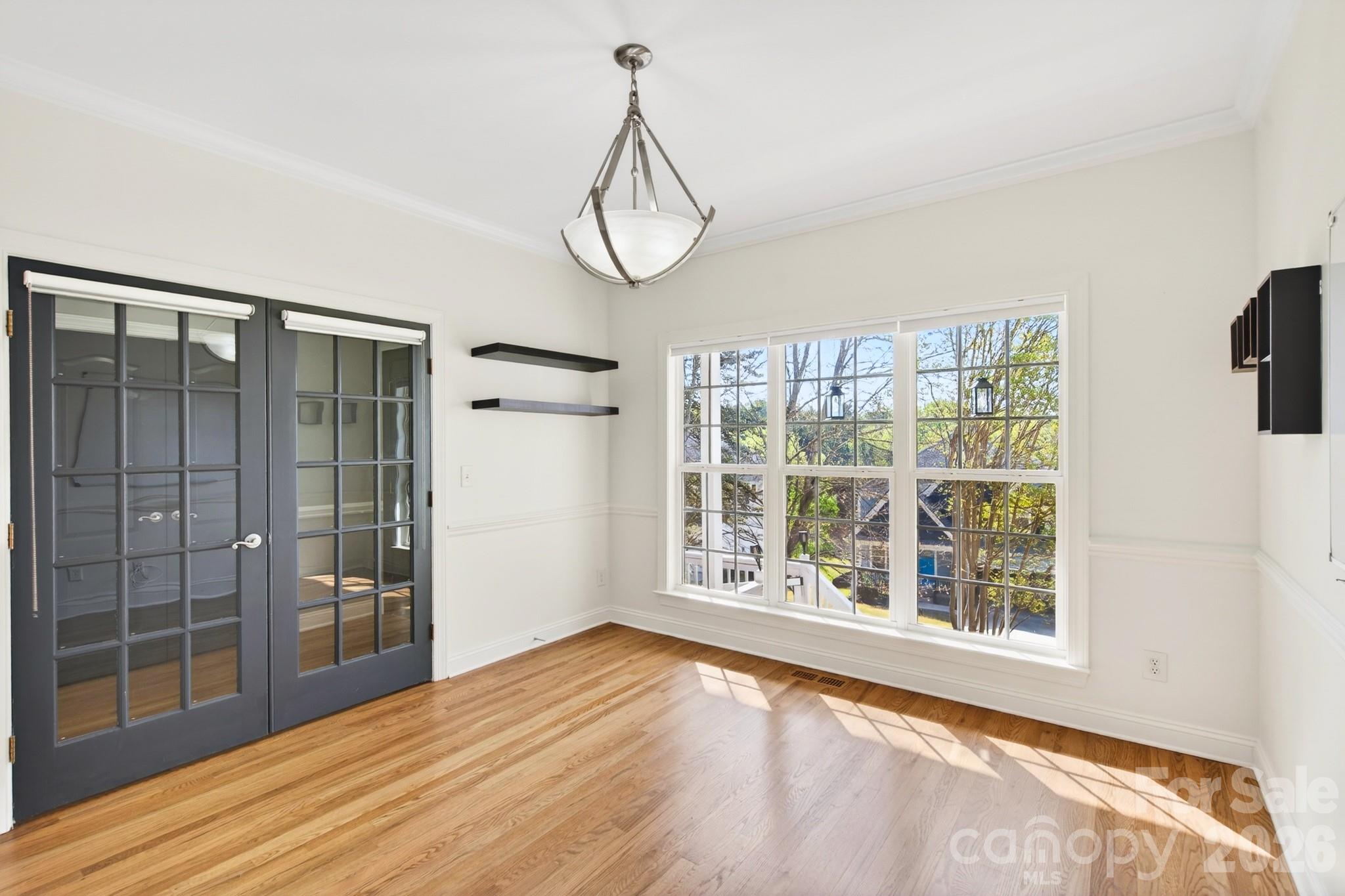 9101 Pitcairn Drive Tega Cay, SC 29708 - Photo 10 of 48 a view of an empty room with wooden floor and a window