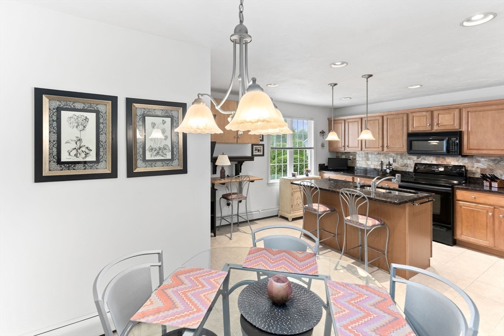 11 Deirdre Circle, Unit 11 Rehoboth, MA 02769 - Photo 6 of 17 a kitchen with stainless steel appliances kitchen island granite countertop a microwave a stove and a wooden floors