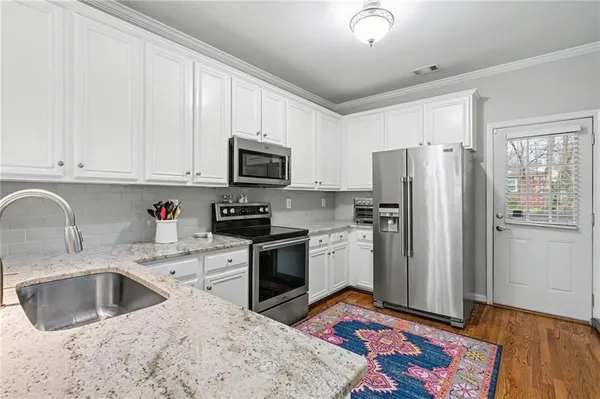 a kitchen with stainless steel appliances granite countertop a refrigerator sink and stove
