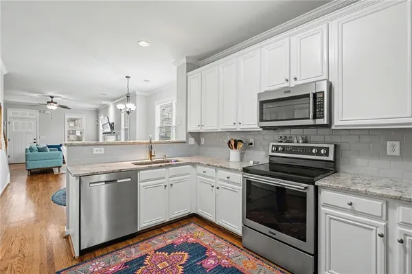 a kitchen with stainless steel appliances granite countertop a stove a sink and a microwave