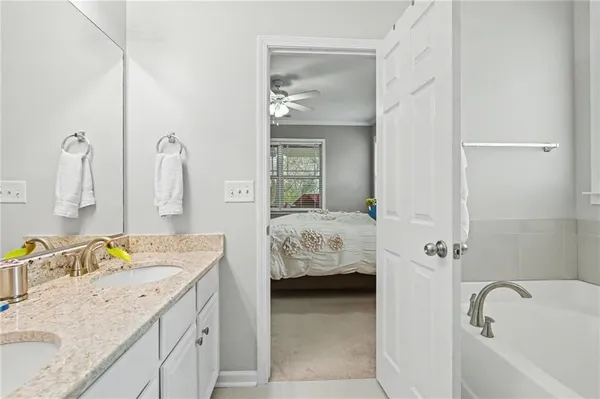 a en suite bathroom with a granite countertop sink and a mirror