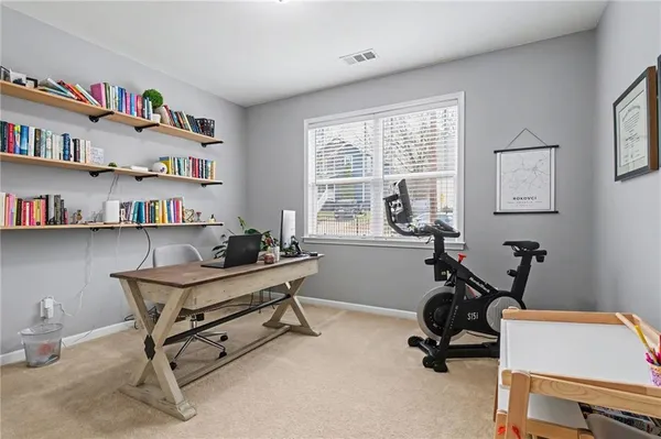 a view of a workspace with furniture and a window