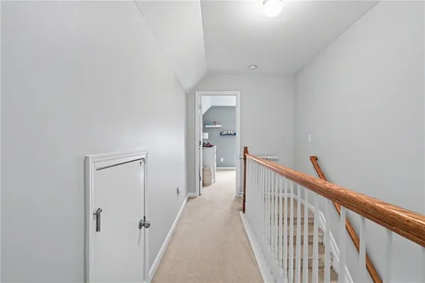 a view of a hallway with a white walls and stairs