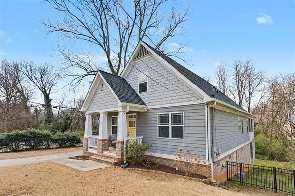 a front view of a house with yard and parking