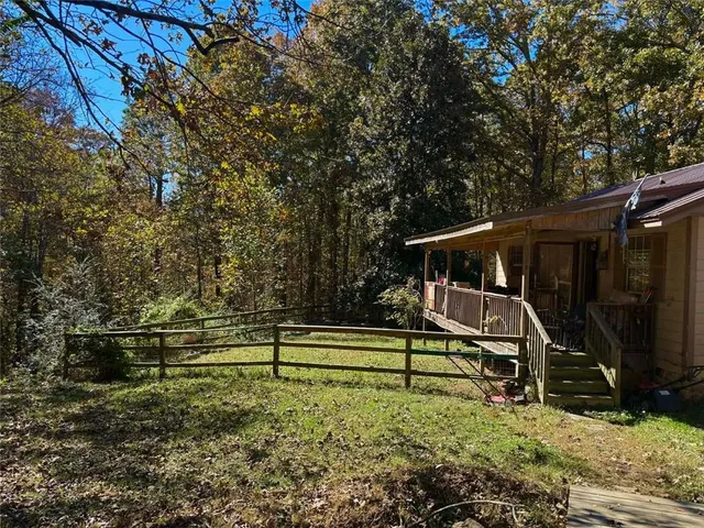 a view of backyard with wooden fence and a large tree