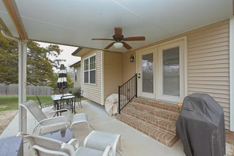 a view of house with backyard and outdoor seating