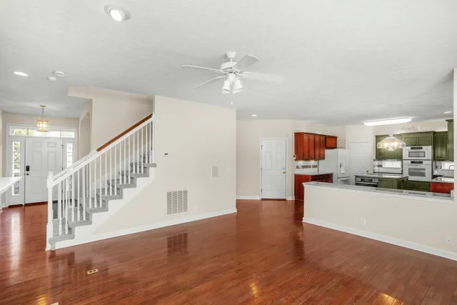 a view of a livingroom with wooden floor and a ceiling fan