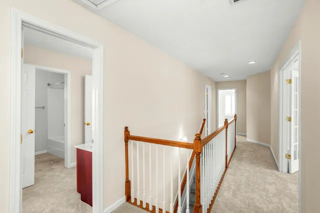 an empty room with chandelier fan and windows