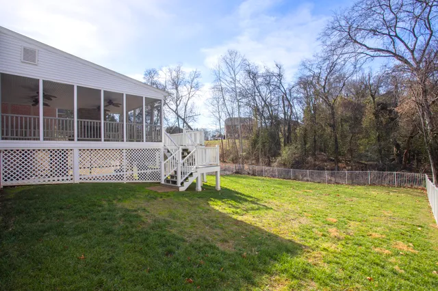 a front view of residential houses with yard and trees
