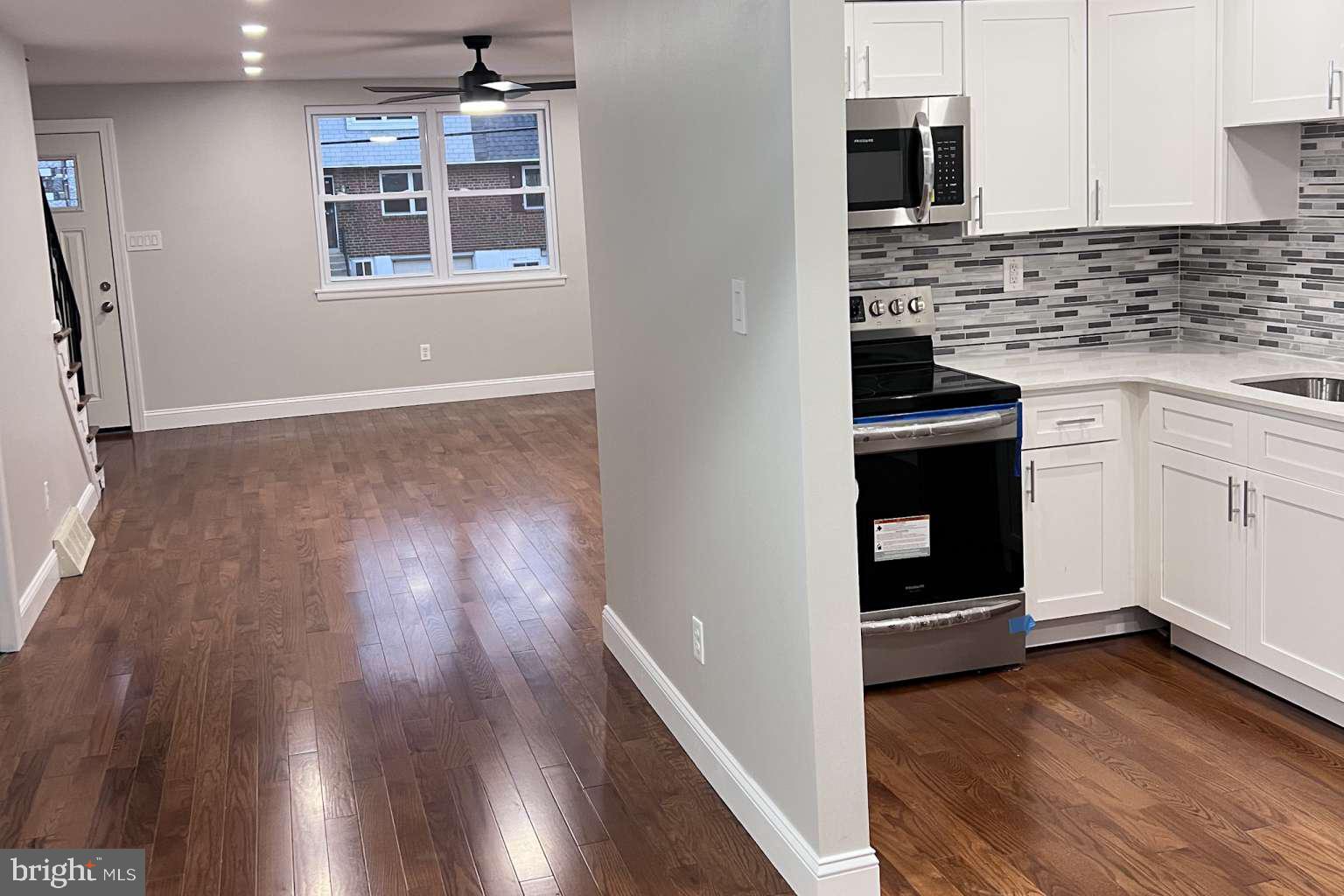 1225 Rainer Road Brookhaven, PA 19015 - Photo 14 of 15 a kitchen with kitchen island wooden floors and appliances