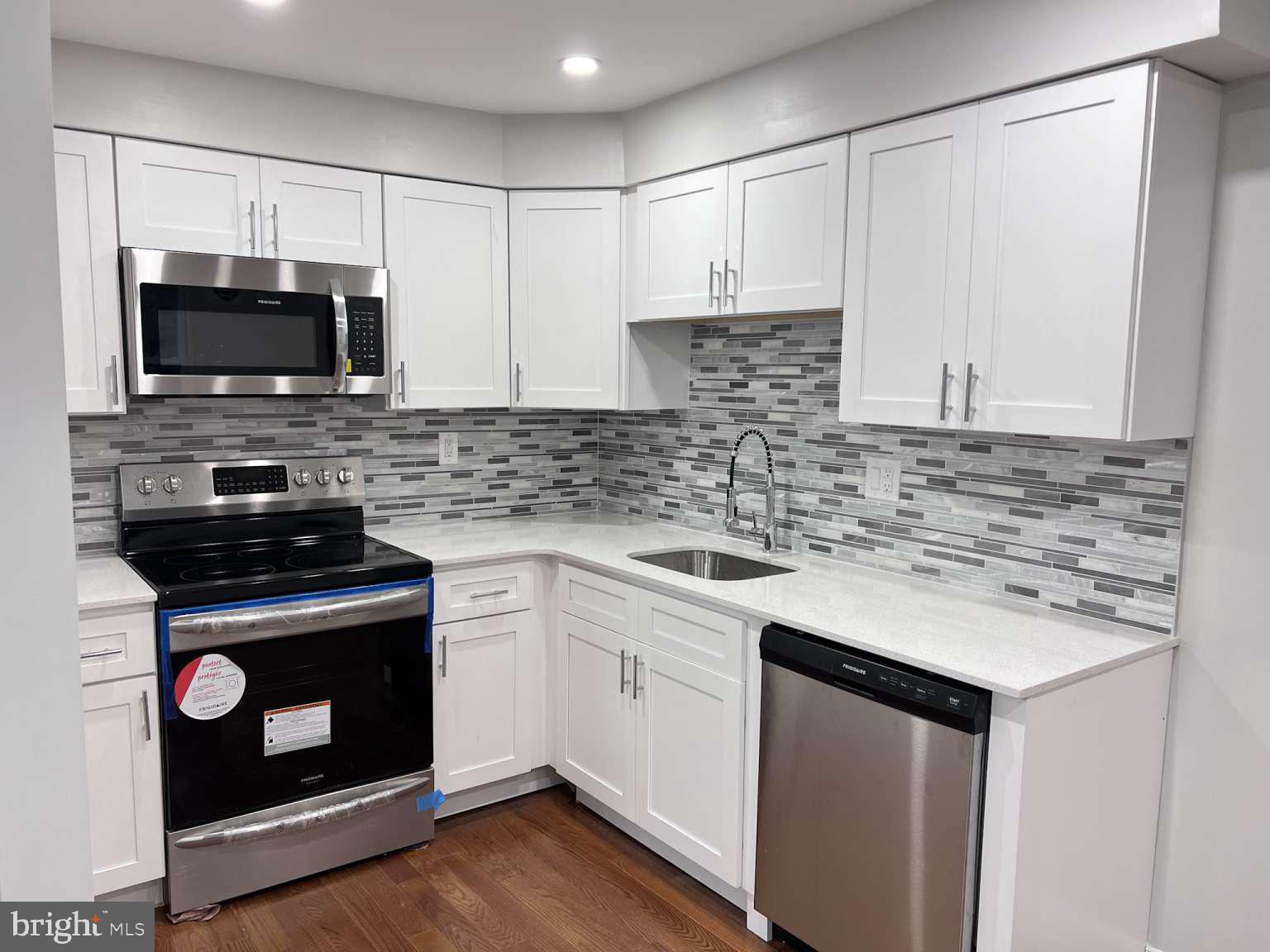 1225 Rainer Road Brookhaven, PA 19015 - Photo 2 of 15 a kitchen with cabinets stainless steel appliances a sink and a microwave