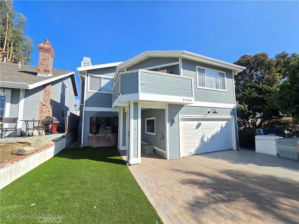 34516 Via Verde, Unit B Dana Point, CA 92624 - Photo 1 of 1 a front view of a house with a yard and garage
