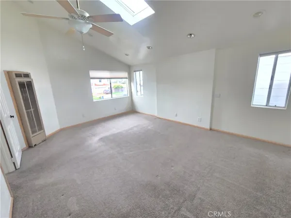 en empty room with windows and ceiling fan