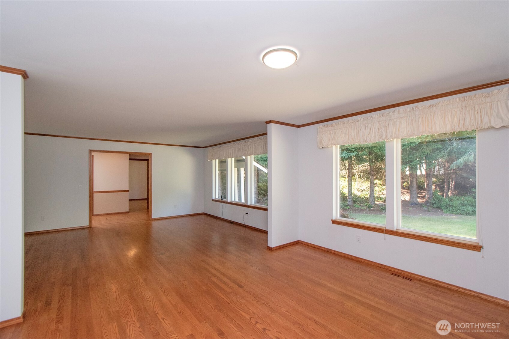 99 South Point Road Port Angeles, WA 98363 - Photo 5 of 40 an empty room with wooden floor and windows